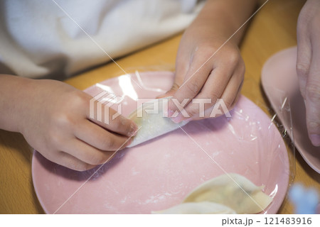 家庭で餃子を作る子供の手元 家庭で餃子を作る子供の手元 121483916