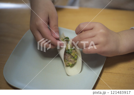 家庭で餃子を作る子供の手元 121483917