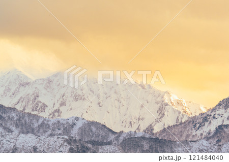 夕日に染まった雲をかぶる八海山 121484040