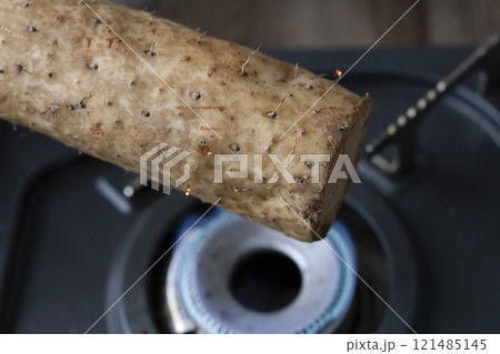 コンロで長芋のひげ根を焼く 121485145