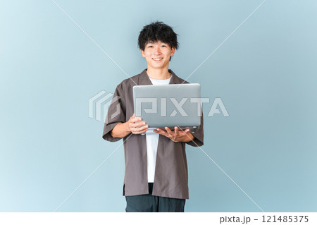 パソコンを持つデジタルネイティブ世代の若い男性 121485375