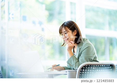 パソコンで仕事をする女性　カフェで仕事中の女性 121485883
