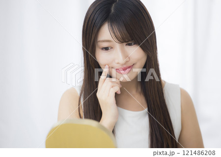 鏡を見て肌を気にする若い女性 鏡を見て肌を気にする若い女性 121486208