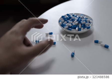 オーバードーズ　ODイメージ　大量の薬を接種する手　薬物過剰摂取　ストレス　鬱病　若年層　社会問題 121486586