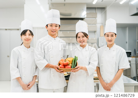 野菜を持つコックコート姿のシェフ・コック・調理師の男女 121486729