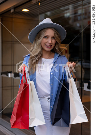 Young woman walking down street with bags after shopping. Shopping in the mall Young woman walking down street with bags after shopping. Shopping in the mall 121486988