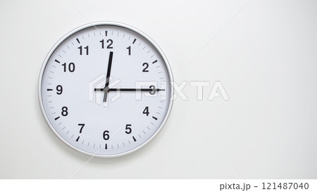Minimalist White Clock with Silver Frame Striking 12.15/00.15 on White Background. Perfect for Time Management and Corporate Campaigns 121487040