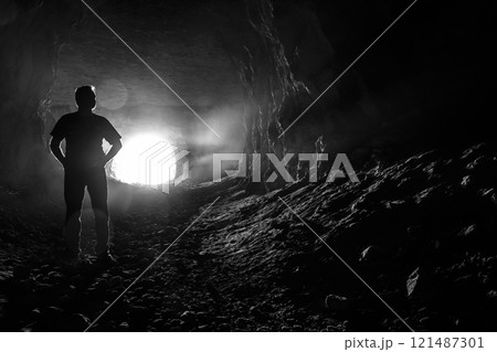 Silhouette of a man in a cave Silhouette of a man in a cave 121487301