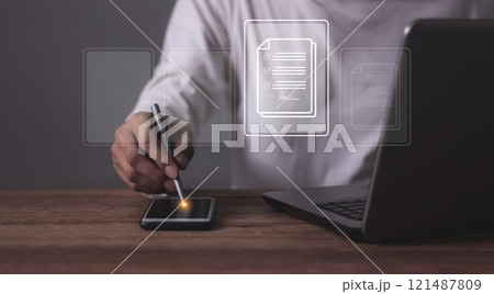 Young man with smartphone mobile and laptop hand using a pen touching to sign a Contract signing Young man with smartphone mobile and laptop hand using a pen touching to sign a Contract signing 121487809