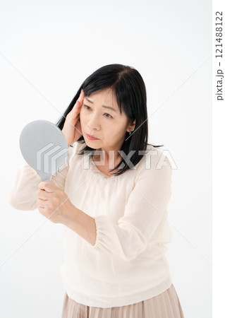 鏡を見るシニア女性　悩む 121488122