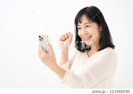 女性　シニア　スマホ　ガッツポーズ 121488290