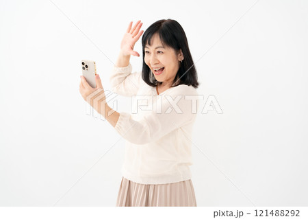 女性　シニア　スマホ　笑顔　驚く 121488292
