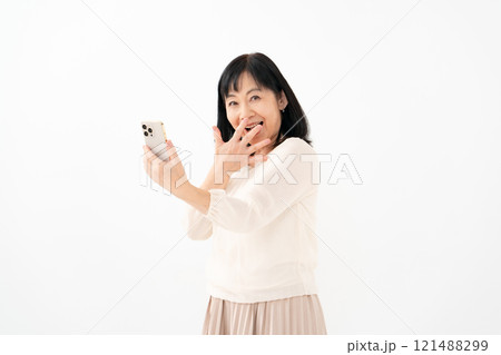 女性　シニア　スマホ　笑顔　驚く 121488299