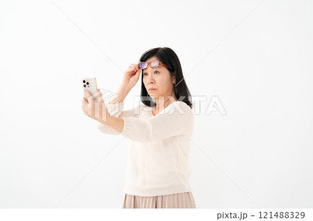 女性　シニア　スマホ　老眼 121488329