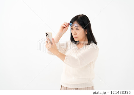 女性　シニア　スマホ　老眼 121488356