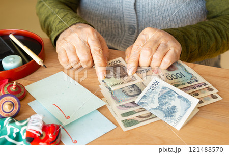 お年玉を準備する高齢者 孫のお年玉を用意するおばあちゃん 年金からお年玉を捻出 お年玉を準備する高齢者 孫のお年玉を用意するおばあちゃん 年金からお年玉を捻出 121488570
