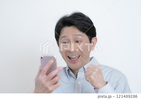 スマホの画面を見て喜ぶミドル男性 スマホの画面を見て喜ぶミドル男性 121489286