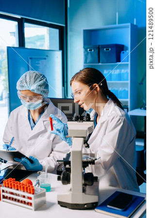 Young scientists conducting research investigations in a medical laboratory, a researcher in the foreground 121489500