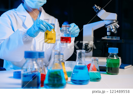 Scientist mixing chemical liquids in the chemistry lab. Researcher working 121489558