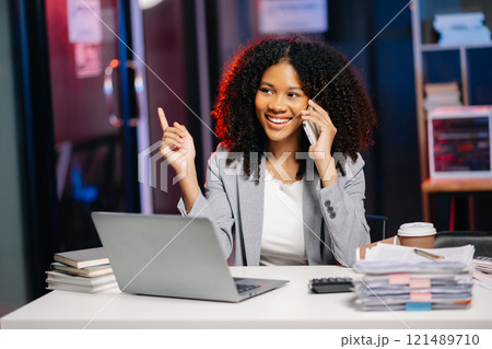 Business woman drinking coffee to get some energy for working overtime sitting at desk using computer and doing overtime project 121489710
