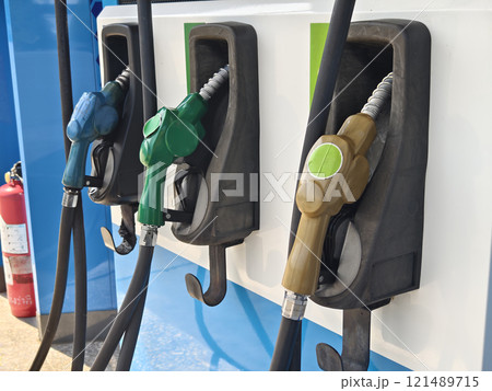 Fuel dispenser nozzles for various types of fuel, arranged at a gas station. 121489715