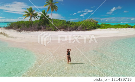 Beautiful woman enjoying tropical holidays on a secluded island with crystal-clear waters and white sands, creating a serene and luxurious vacation moment Beautiful woman enjoying tropical holidays on a secluded island with crystal-clear waters and white sands, creating a serene and luxurious vacation moment 121489719