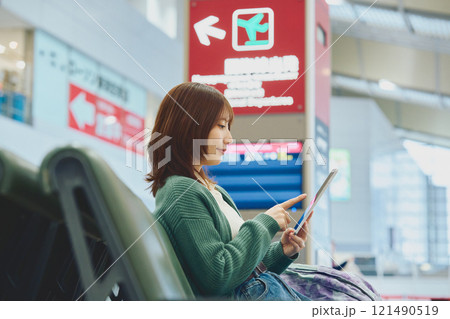 空港で搭乗を待つこれから一人旅に出かける女性 空港で搭乗を待つこれから一人旅に出かける女性 121490519