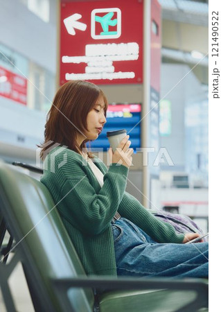 空港で搭乗を待つこれから一人旅に出かける女性 121490522