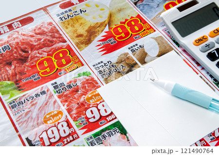 新聞折り込みチラシを見ながら特売品をメモするイメージ 121490764