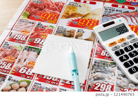 新聞折り込みチラシを見ながら特売品をメモするイメージ 新聞折り込みチラシを見ながら特売品をメモするイメージ 121490765