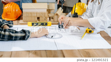 Creative architect projecting on the big drawings with architectural project at construction site 121491321