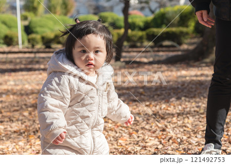 【落ち葉で敷き詰められた冬の公園で遊ぶ1歳児 立つ】 【落ち葉で敷き詰められた冬の公園で遊ぶ1歳児 立つ】 121492753