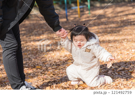 【落ち葉で敷き詰められた冬の公園で遊ぶ1歳児 立つ】 【落ち葉で敷き詰められた冬の公園で遊ぶ1歳児 立つ】 121492759