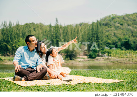 Asian family father mother and daughter sitting on blanket spring meadow field grass sunny day in park cheerful sweet kid girl, parents and child picnic enjoying outdoors together, Family relaxation Asian family father mother and daughter sitting on blanket spring meadow field grass sunny day in park cheerful sweet kid girl, parents and child picnic enjoying outdoors together, Family relaxation 121494370