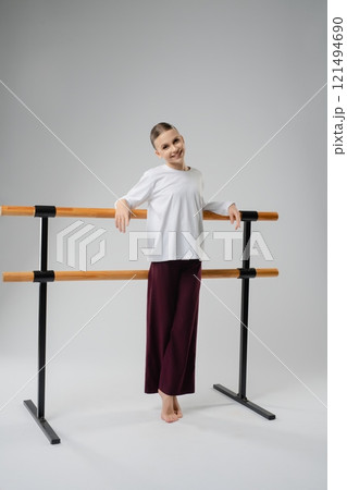 Girl enjoying a moment of joy while posing by a dance barre 121494690