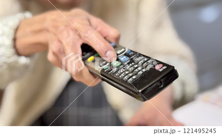 テレビのリモコンを向ける高齢女性の手 テレビのリモコンを向ける高齢女性の手 121495245