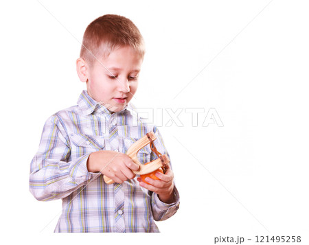 Young boy use sling shot shoot mandarine. Young boy use sling shot shoot mandarine. 121495258