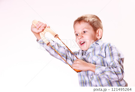 Young boy use sling shot shoot mandarine. Young boy use sling shot shoot mandarine. 121495264