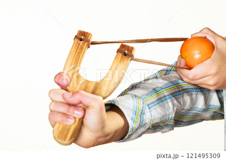 Kid holding slingshot in hands 121495309