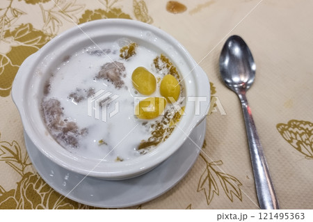 A serving of Orh Nee in bowl with spoon. It is popular traditional teochew sweet dessert consisting yam and gingko. 121495363