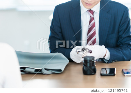 中古品の査定をする買取業者と主婦　顔無し 121495741