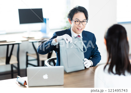 バックの査定をする買取業者と主婦 121495743