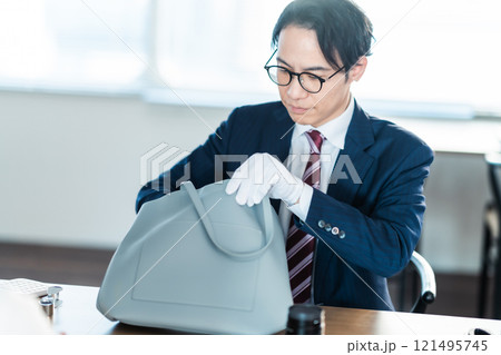 バックの査定をする買取業者と主婦 121495745