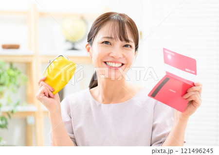 財布と通帳を持って喜ぶミドル女性 121496245