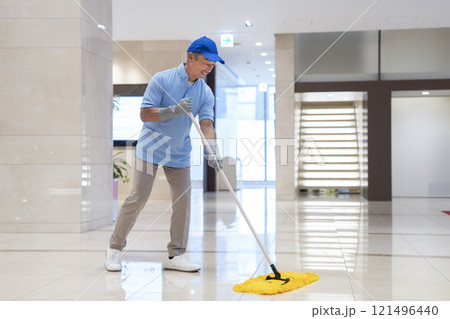 ビル清掃イメージ　モップで床を拭く60代の男性クリーニングスタッフ 121496440