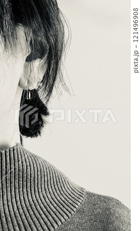 50代女性の耳元のモノクロ写真 121496908