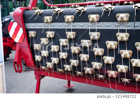 Agricultural machinery close-up with metal components and red frame. 121498722