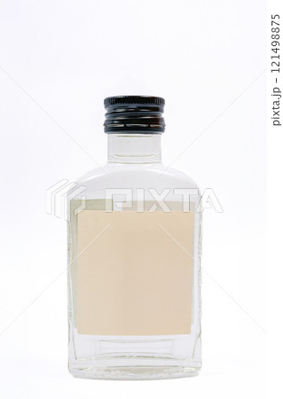 a small glass bottle with a clear liquid. a small bottle of Russian vodka 121498875