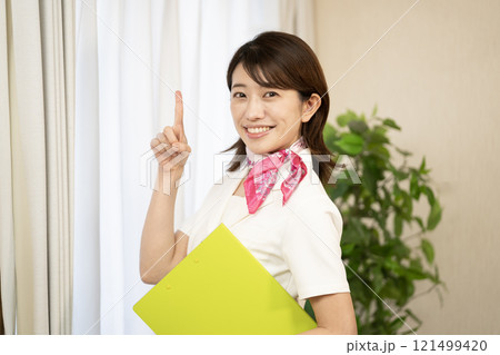 人差し指を立てて微笑むエステティシャン 121499420