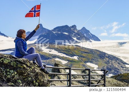 Tourist with norwegian flag in mountains 121500494